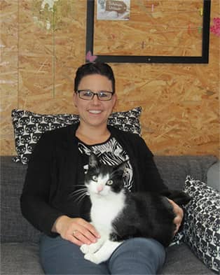 Stefanie Hameister, Inhaberin der Katzenpension Honigsee, mit einer schwarz-weißen Katze auf dem Arm